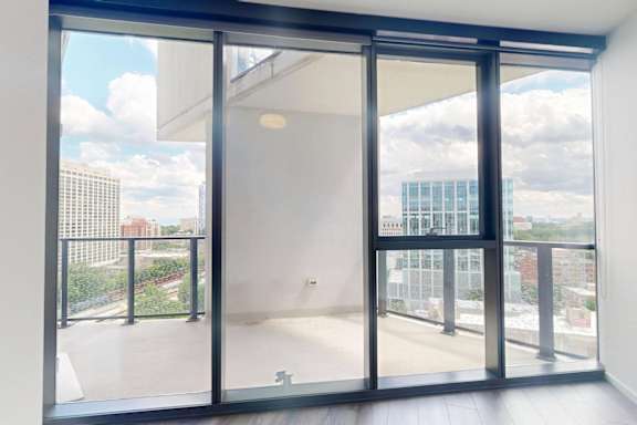 A room with a view of the city through large windows.