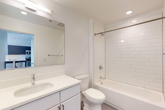 A white bathroom with a sink, toilet and bathtub.