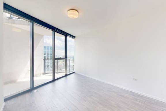 A room with a sliding glass door leading to a balcony.