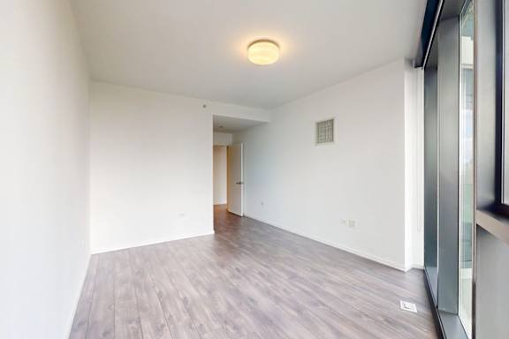 A room with a wooden floor and a ceiling light.