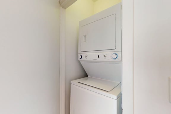 A white dryer is built into a wall.