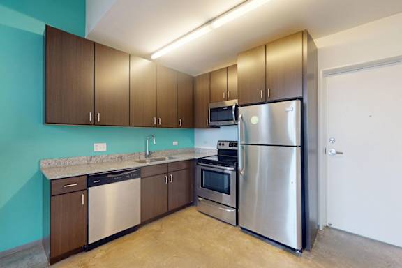 A kitchen with a blue wall and a stainless steel refrigerator.