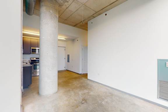 A room with a white wall and a concrete pillar.