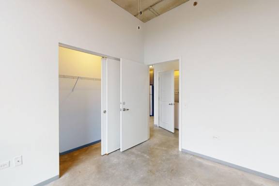 A white door is open in a room with a concrete floor.