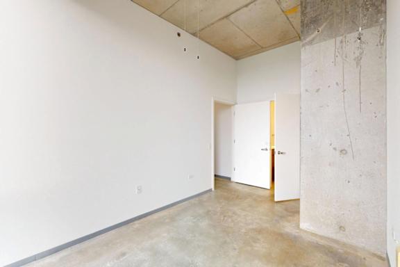 A room with a white wall and a door.