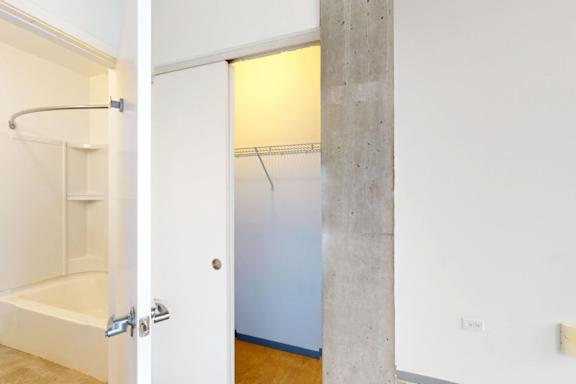 A white bathroom with a shower and a towel rack.