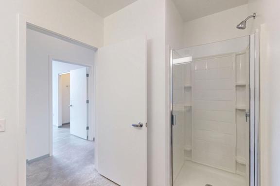 A white bathroom with a walk in shower.