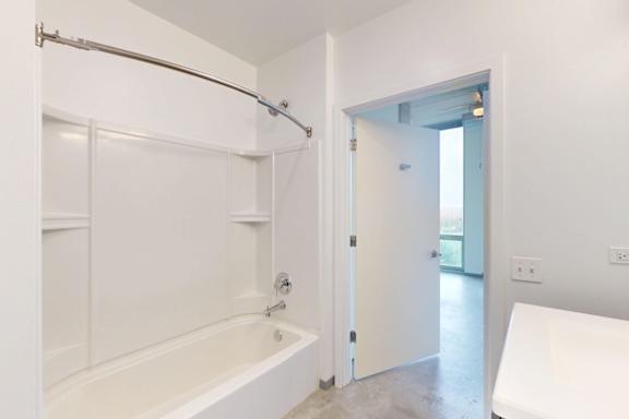 A white bathroom with a tub and a shower.