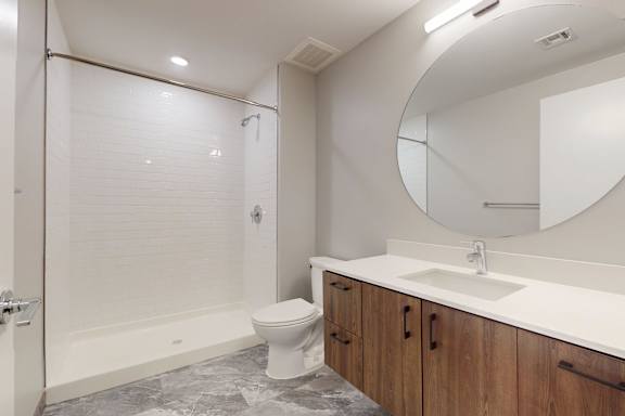 A bathroom with a toilet, sink, and shower.
