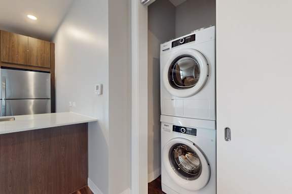 A white washing machine is in a small laundry room.