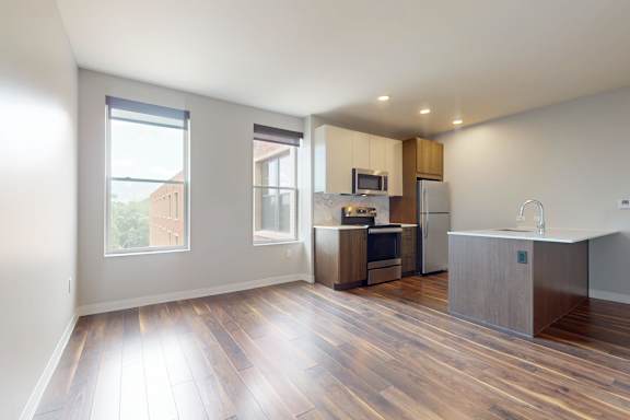 A kitchen with wooden floors and a large window.