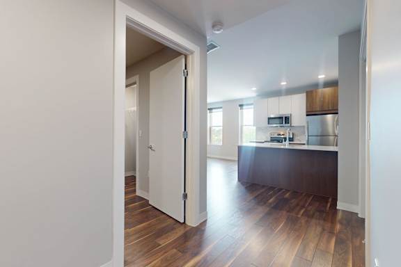 A kitchen with a wooden floor and white walls.