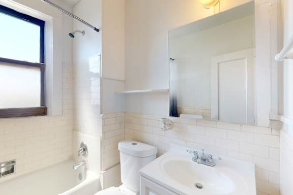 A white toilet sits next to a white sink in a bathroom.