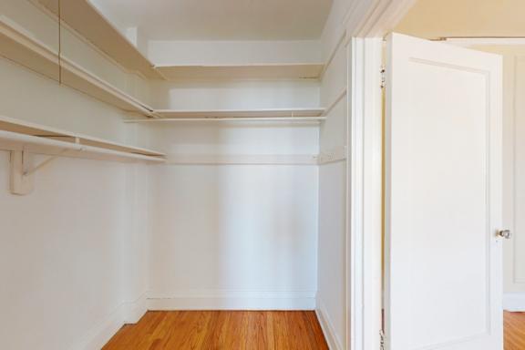 A white room with a wooden floor and a white door.