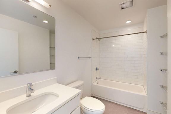 A white bathroom with a toilet, sink, and bathtub.