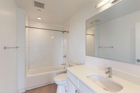 A white bathroom with a toilet, sink, and bathtub.
