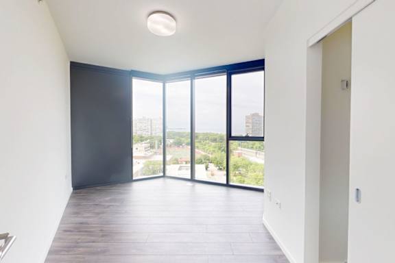 A room with a large window and a view of the city.