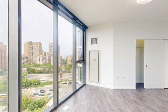 A room with a view of the city through large windows.
