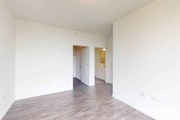 A large empty room with wooden floors and white walls.