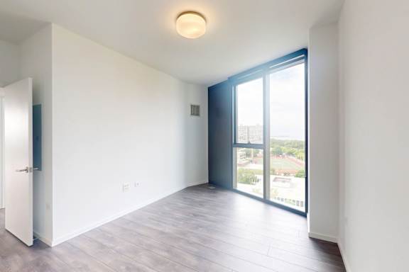 A room with a sliding glass door leading to a balcony.