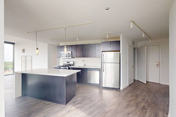 A modern kitchen with a large island and stainless steel appliances.