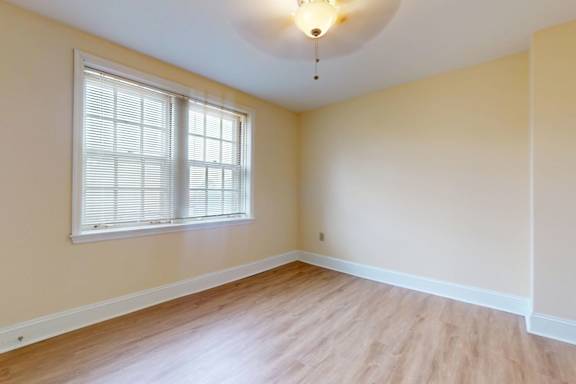 A room with a window and wooden flooring.