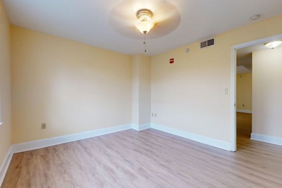 A room with wooden flooring and a ceiling light.