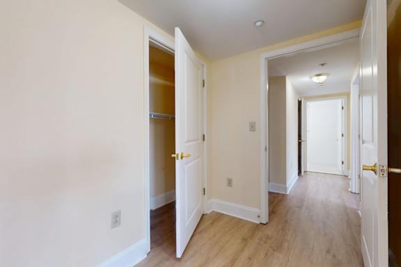 A hallway with white doors and wood floors.