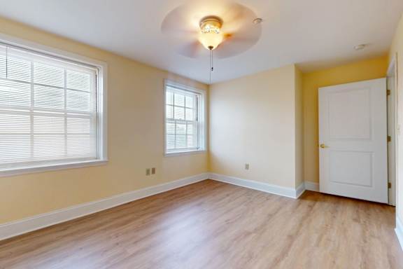 A room with a white door and a window with blinds.