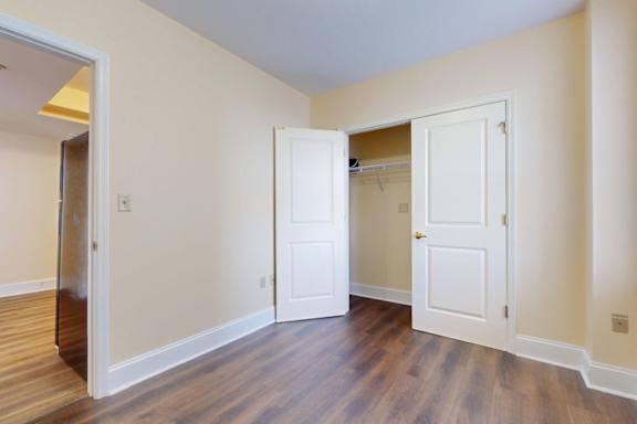 A room with two white doors and a wooden floor.