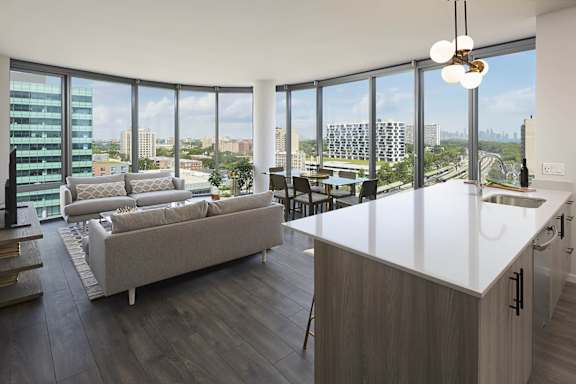 A modern kitchen and living room with a view of the city.