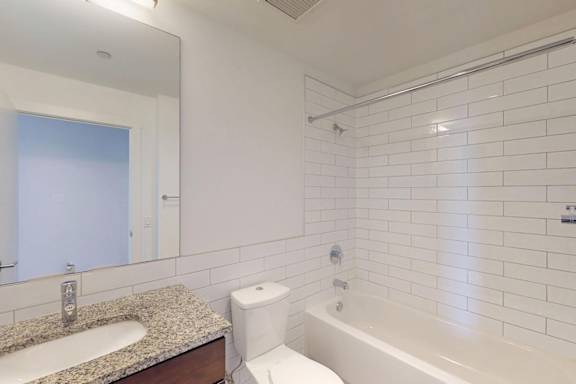 A white bathroom with a sink, toilet, and bathtub.