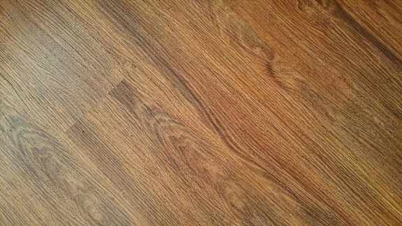 A close up view of a wooden surface with a rich, warm tone.
