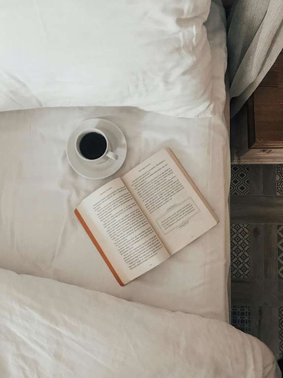 A man in a blue shirt and grey shorts is doing a step aerobics exercise with a trainer in a yellow shirt.