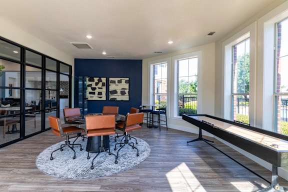 A room with a table and chairs in the middle of the room.