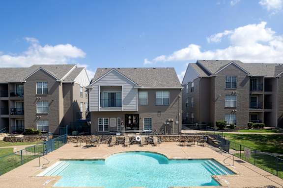 A large swimming pool in front of apartment buildings.