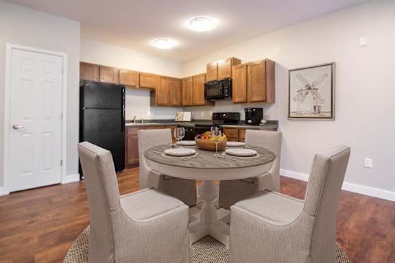 A kitchen with a table and chairs in the middle of the room.