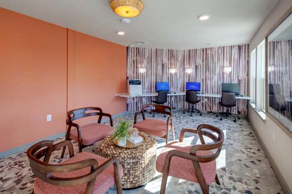 A room with orange walls and a table with chairs.