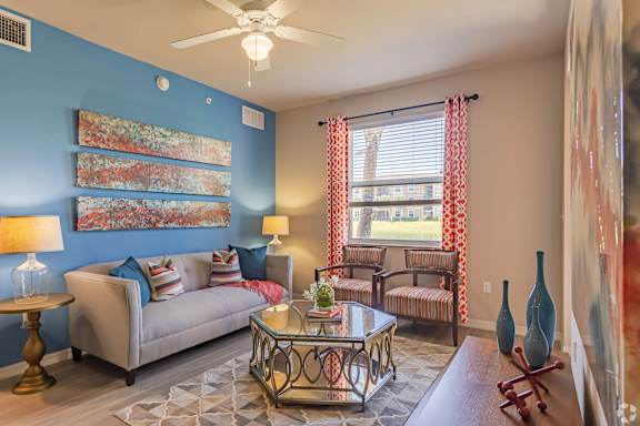 A living room with a sofa, a coffee table, and a painting on the wall.