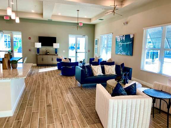A living room with a white couch and blue chairs.