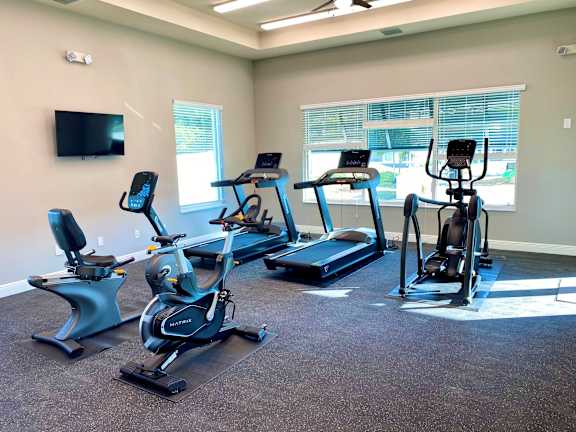 A room with a television and exercise equipment.