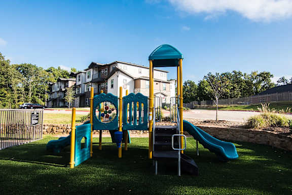 A playground with a blue slide and a yellow and blue play structure.