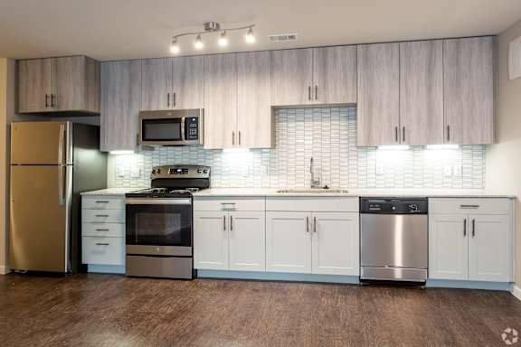 A kitchen with white cabinets and a stainless steel dishwasher.