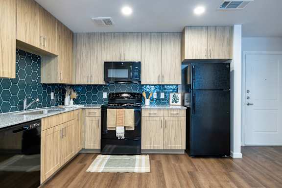 A kitchen with wooden cabinets and black appliances.