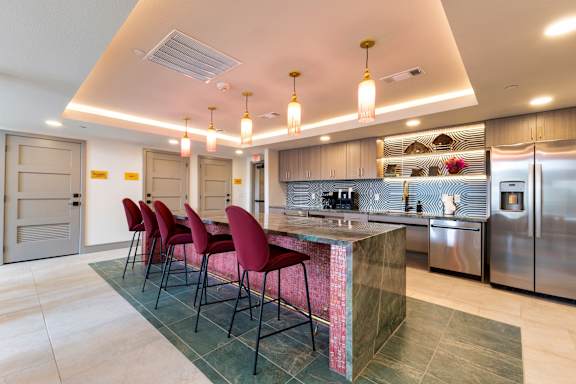 A kitchen with a bar area and chairs.