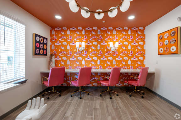 A conference room with orange wallpaper and a white table.