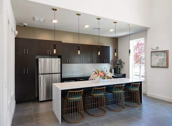 A modern kitchen with a large island and bar stools.