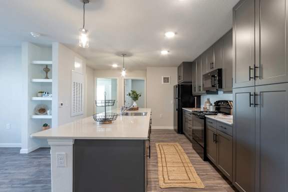A modern kitchen with a large island and stainless steel appliances.