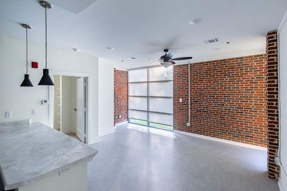A room with a brick wall and a ceiling fan.