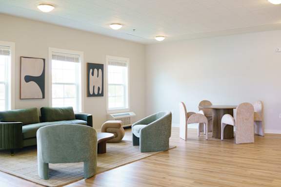A living room with a green chair and a white sofa.